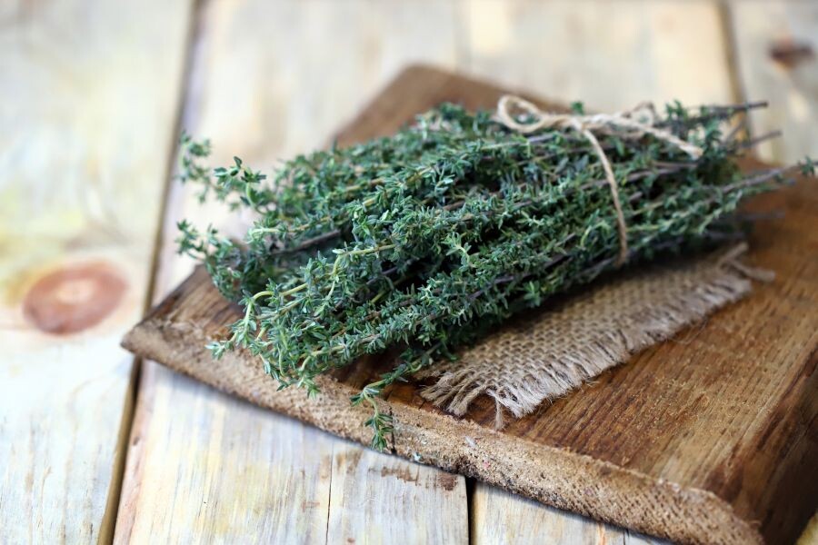Selective focus. A bunch of fresh thyme on a wooden surface.